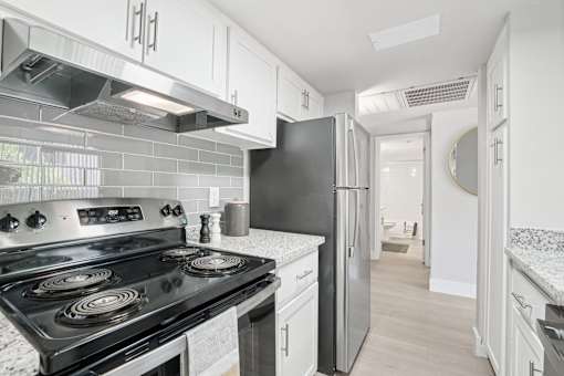 A kitchen with a black stove top oven and a black refrigerator.