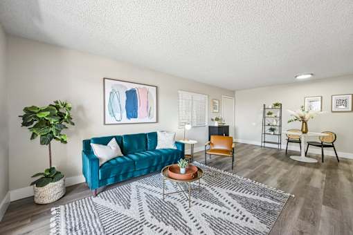 A living room with a blue couch and a grey rug.