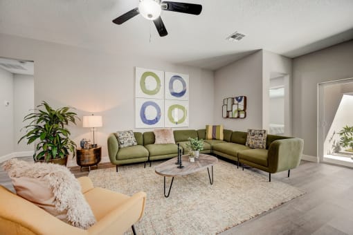Pet-Friendly Rentals in Lady Lake, FL – The Groves at Lake Ella - an open living room with couches and chairs and a ceiling fan