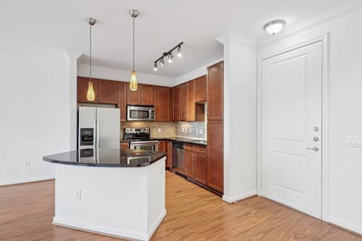 A kitchen with wooden cabinets and a black countertop.