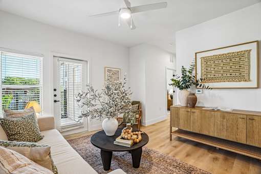 A living room with a white couch, a coffee table, and a ceiling fan.