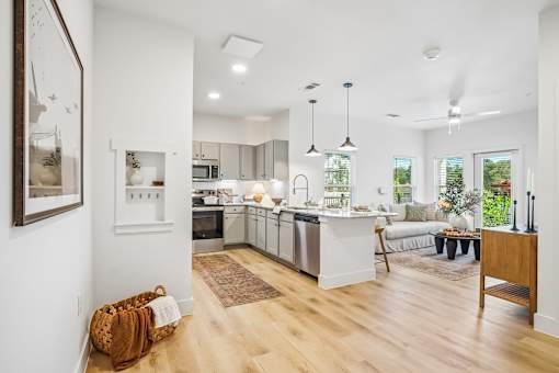 A modern kitchen with wooden floors and white walls.