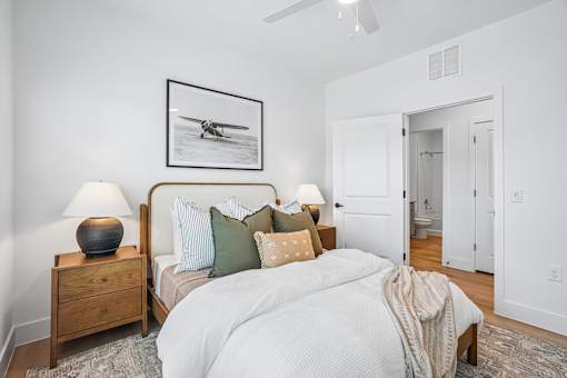 A bedroom with a bed, nightstands, and a picture on the wall.