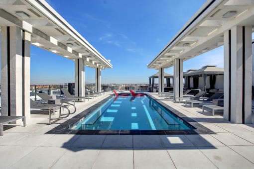 a pool on the roof of a building with a blue sky in the background
