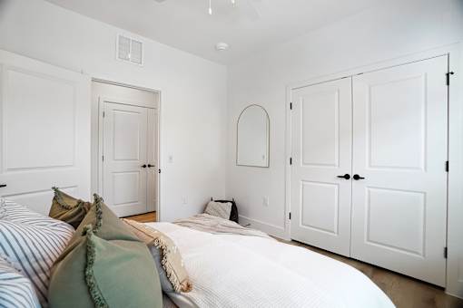 A bedroom with a bed and a mirror on the wall.