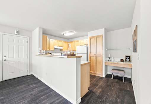 A kitchen with a white counter and wooden cabinets.