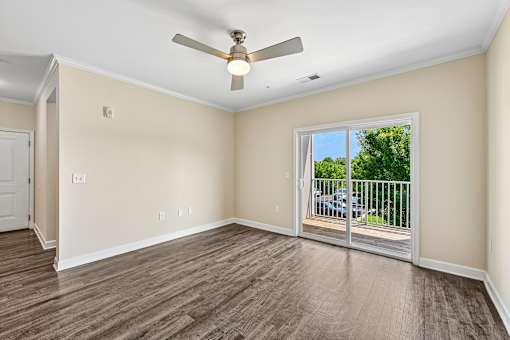 A bright Hawks Landing living space in Hickory NC featuring a ceiling fan and sliding glass doors