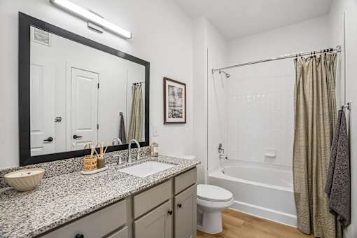 A bathroom with a sink, toilet, and bathtub.