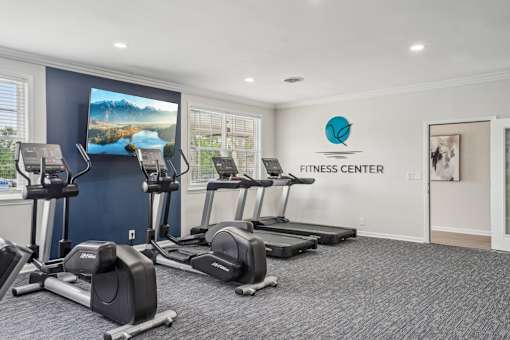 A fitness center with treadmills and elliptical machines.