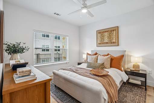 A bedroom with a large bed and a ceiling fan.