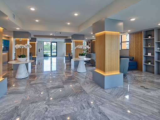 A spacious lobby with marble floors and modern furniture.