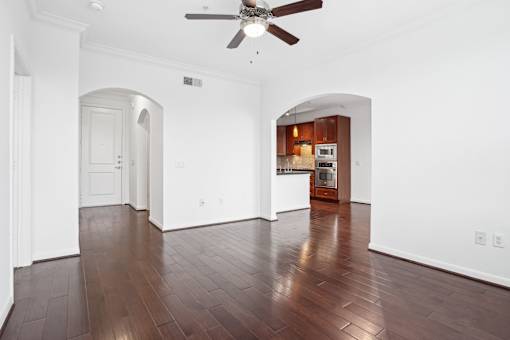 A room with a ceiling fan and wooden floors.