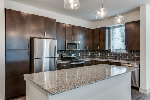 a kitchen with brown cabinets and granite countertops