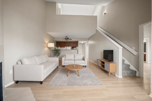 A living room with a white couch and a wooden coffee table.