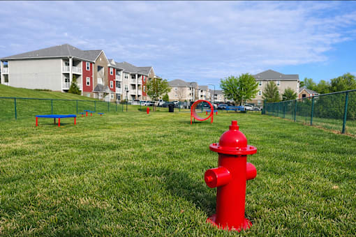 Red fire hydrant in landscaped grassy field at Hawks Landing Apartments in Hickory, NC