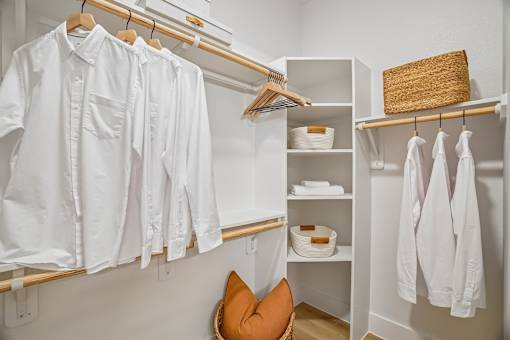 A white shirt is hanging on a clothes rack.