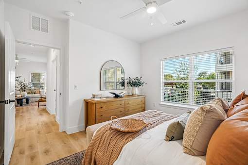 A bedroom with a bed, dresser, and mirror.