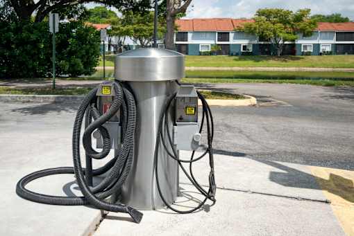 A stainless steel vacuum cleaner machine with a hose coiled up.