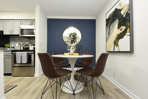 a dining room with a table and chairs and a blue accent wall