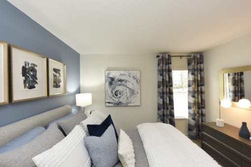 a blue and white bedroom with a couch and a window