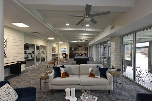A living room with a white couch and a ceiling fan.