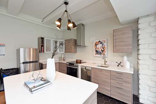 A modern kitchen with a white table and a stainless steel refrigerator.