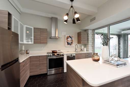 A modern kitchen with a stainless steel refrigerator and a white countertop.