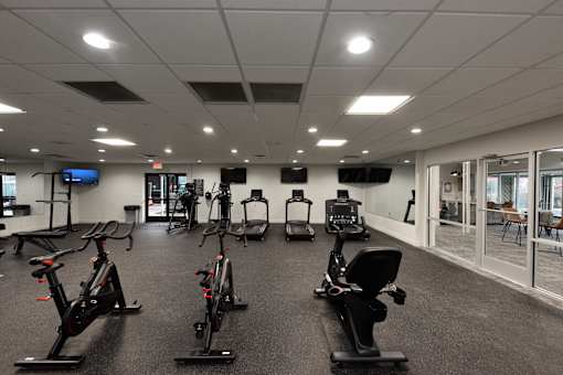 A gym with a row of stationary bikes.