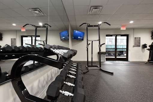 A gym with a row of dumbbells and two treadmills.