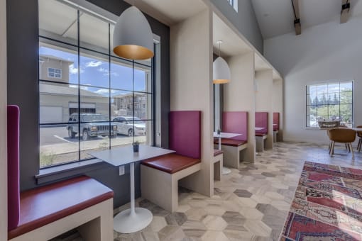 a dining area with tables and chairs and a large window with a view of a parking lot