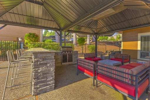 Pet-Friendly Apartments in Beaverton, OR - MonteVista - Outdoor Grill Area with Eat-in Bar, Barstools, Comfortable Seating, and Greenery