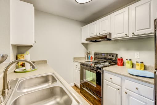 Beaverton Apartments for Rent - MonteVista - Galley Kitchen with White Cabinetry, Granite Countertops, and Fully Loaded Appliances