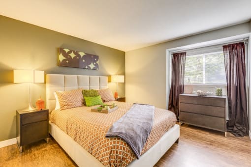 Three Bedroom Apartments in Beaverton, OR - MonteVista - Large Bedroom with Wood Flooring, Queen Bed, Green Accent Wall, and Furniture