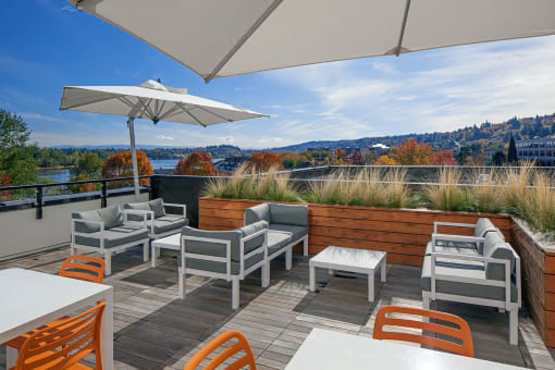 a rooftop deck with chairs and umbrellas
