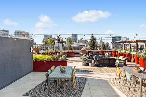 A patio with a table and chairs overlooks a city skyline.