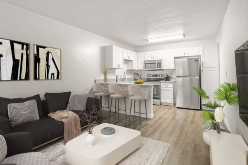 Addison Lane Apartment homes in Gainesville Florida photo of a living room with a kitchen in the background and a large white coffee table in the foreground