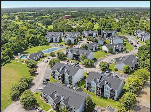 A bird's eye view of a residential area with houses and a swimming pool.