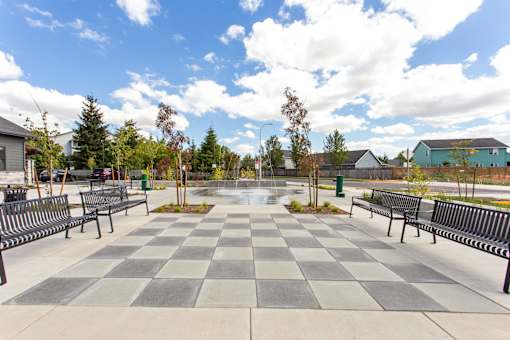 A checkerboard patterned walkway with benches on either side.