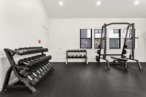 A black and white photo of a gym with weights and exercise equipment.