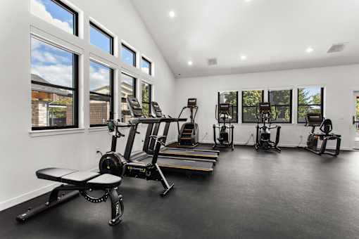 A home gym with a row of exercise bikes and a bench.