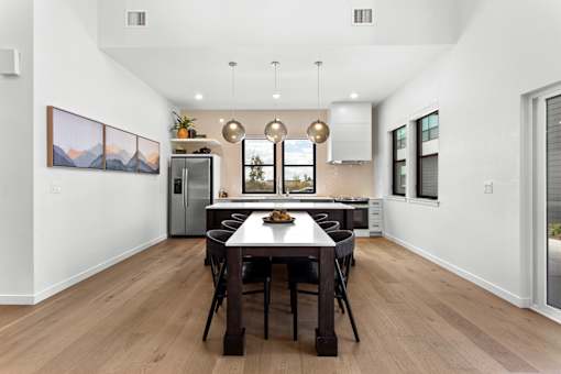 A modern dining room with a wooden table and chairs.