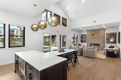 A modern kitchen with a large island and a fireplace in the living room.