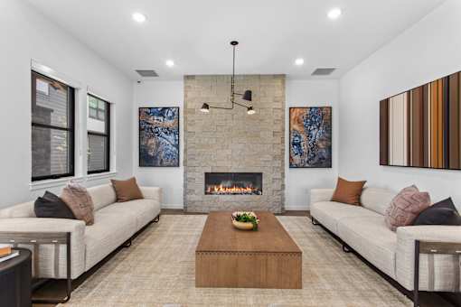 A modern living room with a fireplace and two couches.