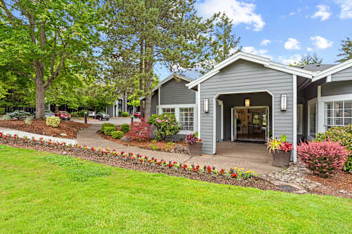 A house with a grey roof and a garden in front.