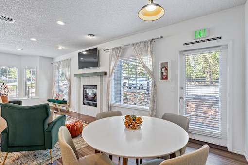 A living room with a white table and chairs.