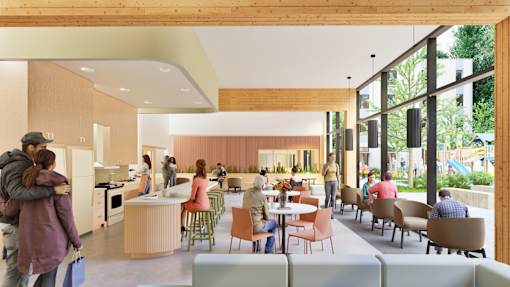 A group of people are gathered in a modern, open-concept kitchen and dining area.