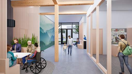 A group of people are gathered in a room with a mural of a mountain scene on the wall.