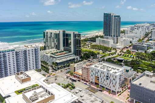 A cityscape with buildings and a beach in the background.