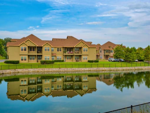 Parc at Rogers exterior building with a pond in front surrounded by a gate