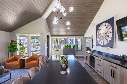 a kitchen and living room with a long black table and chairs